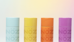 An array of Nöz sunscreen colors (left to right: blue, yellow, orange, purple) to choose from.